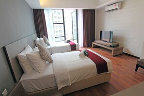 A hotel room with two beds, a TV, and a large window with curtains.