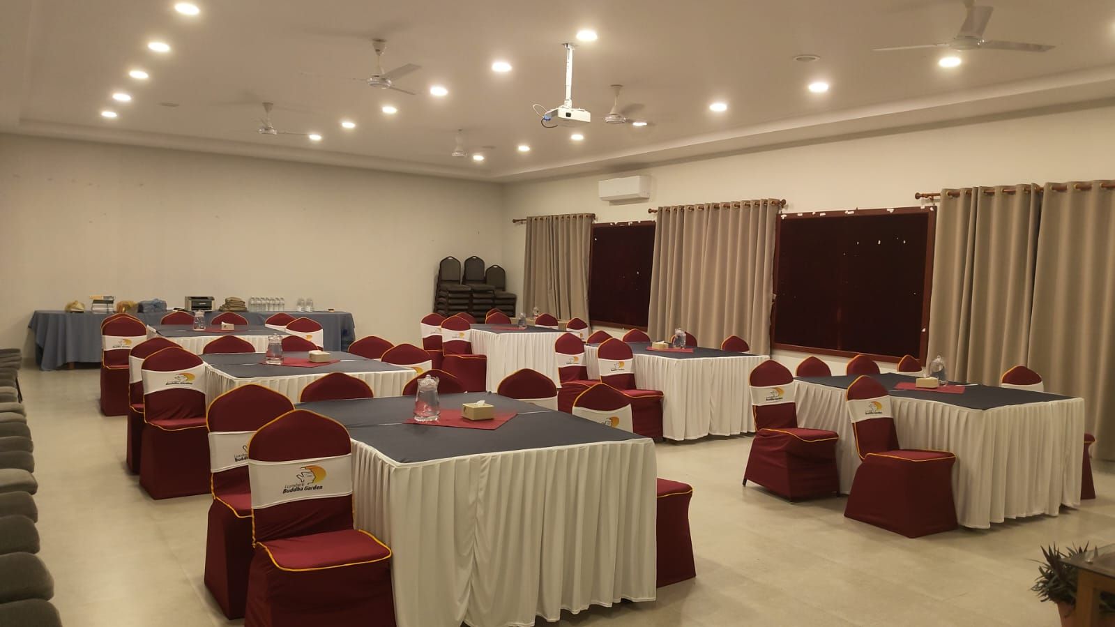 A conference room with multiple tables and chairs, arranged for meetings or events.