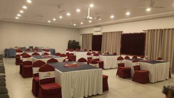 A conference room with multiple tables and chairs, arranged for meetings or events.