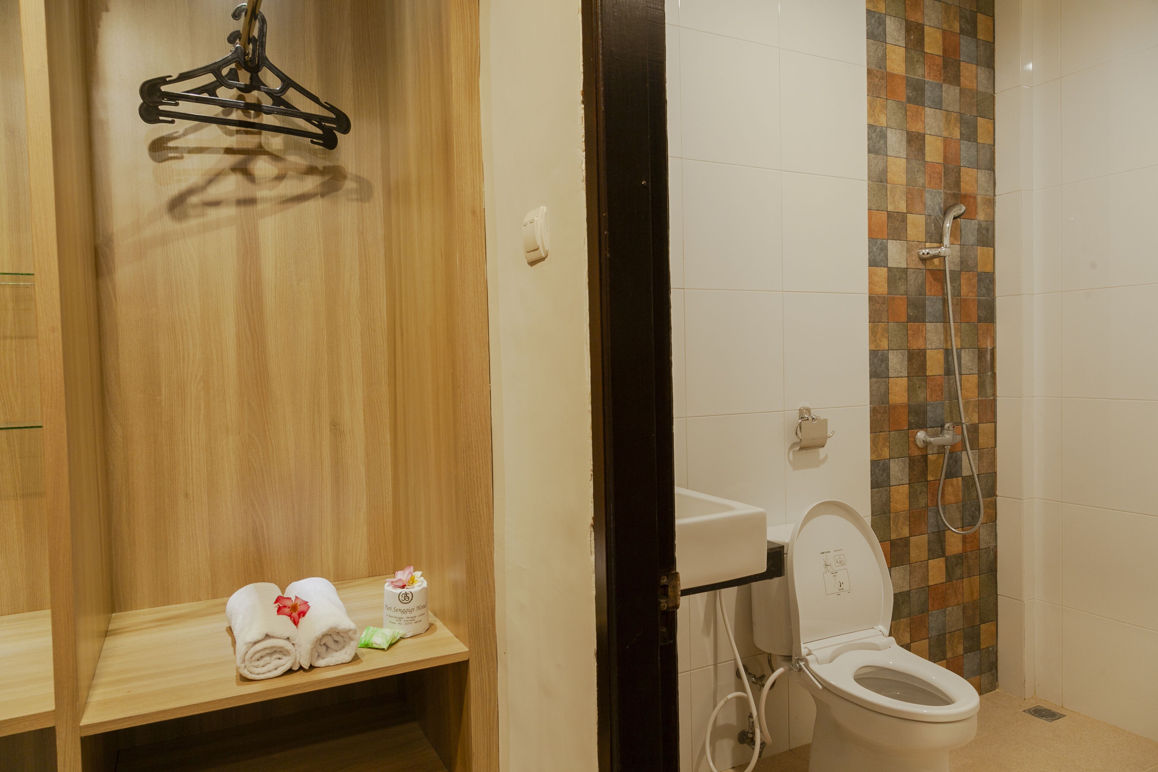 A bathroom with a wooden vanity, a towel rack, a toilet, and a shower area.