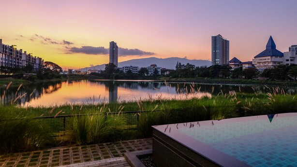 Vista de un lago con edificios modernos y un cielo despejado.