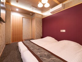 Una habitación de hotel con cama, armario y una lámpara en el techo.