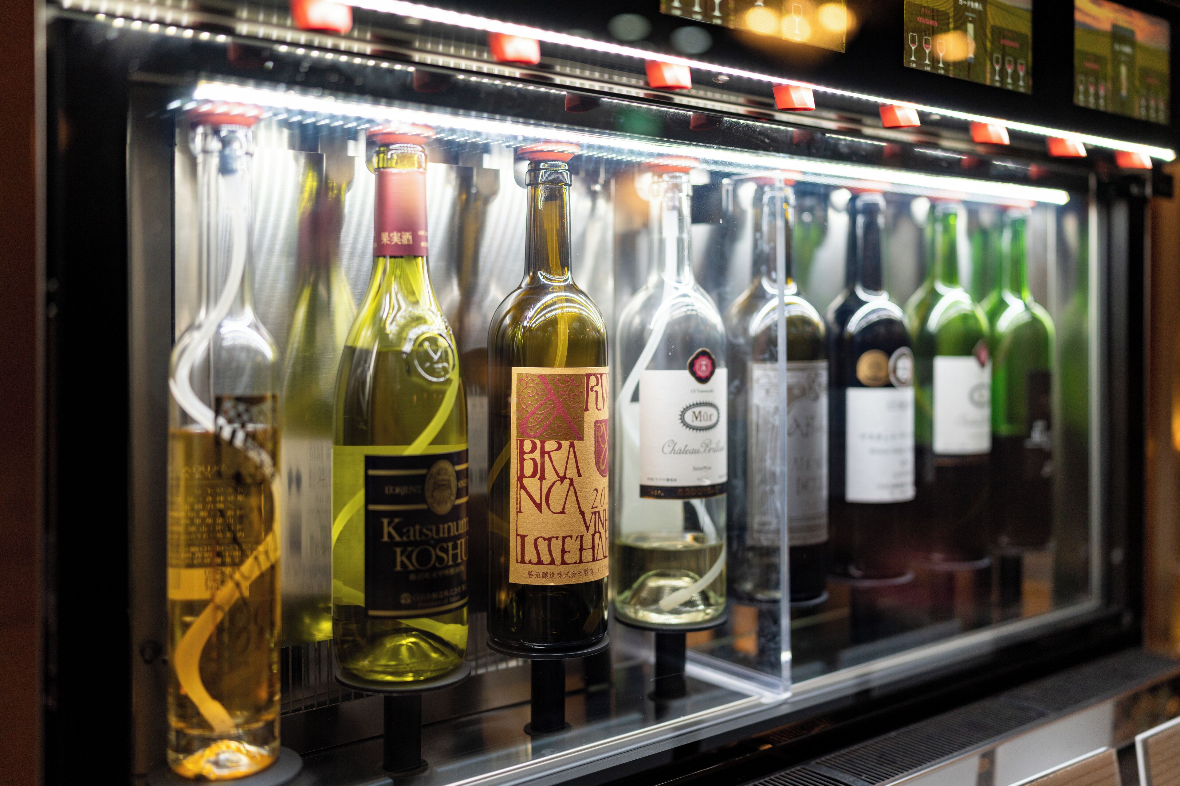 A refrigerated display case containing various bottles of wine.