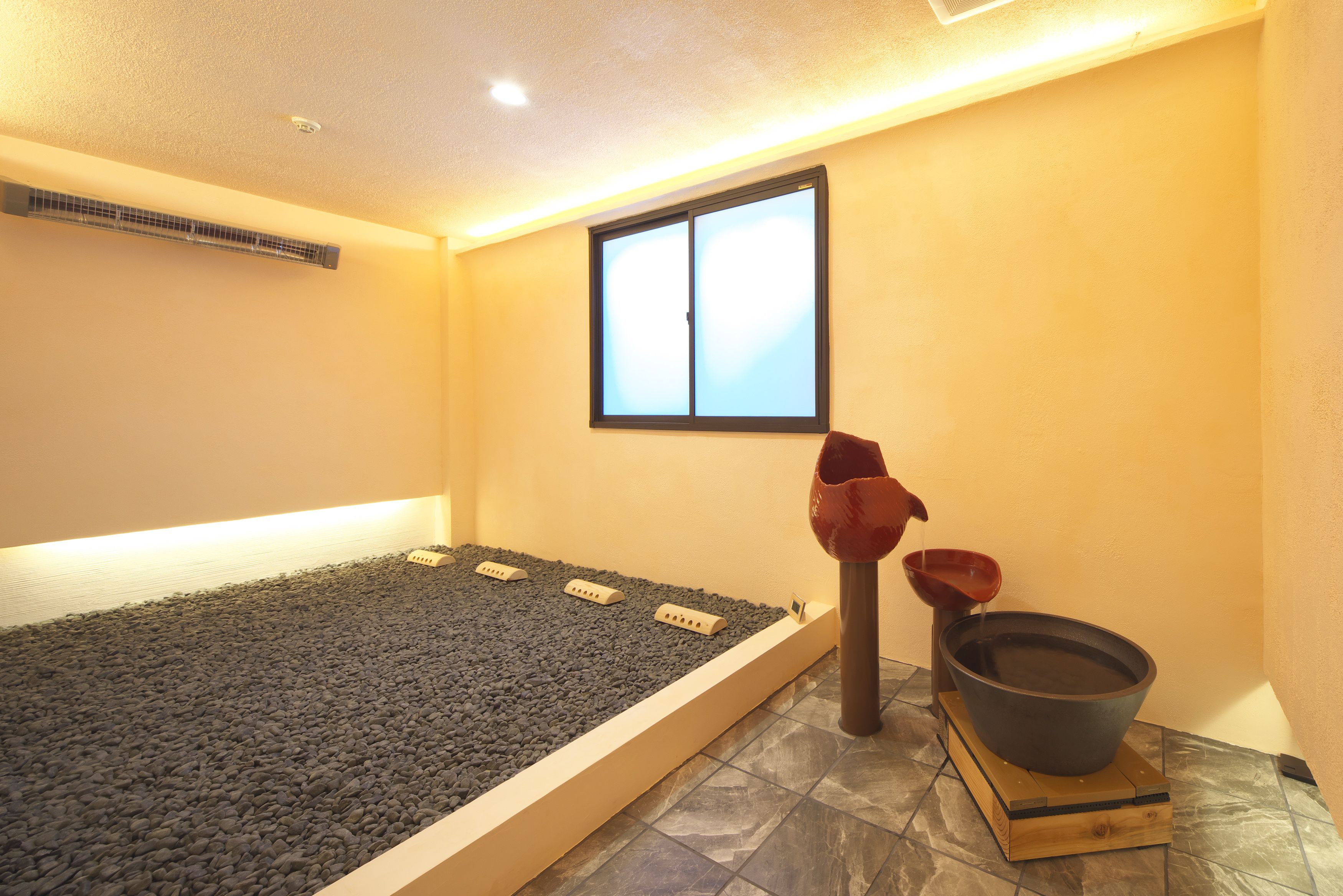 A room with a heated floor, a window, and a water feature.