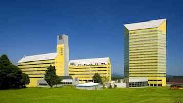 A yellow building with a white roof, multiple windows, and a chimney.