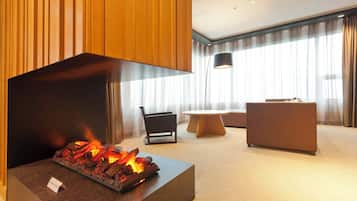 A modern living room with a fireplace, a round table, and a sofa.
