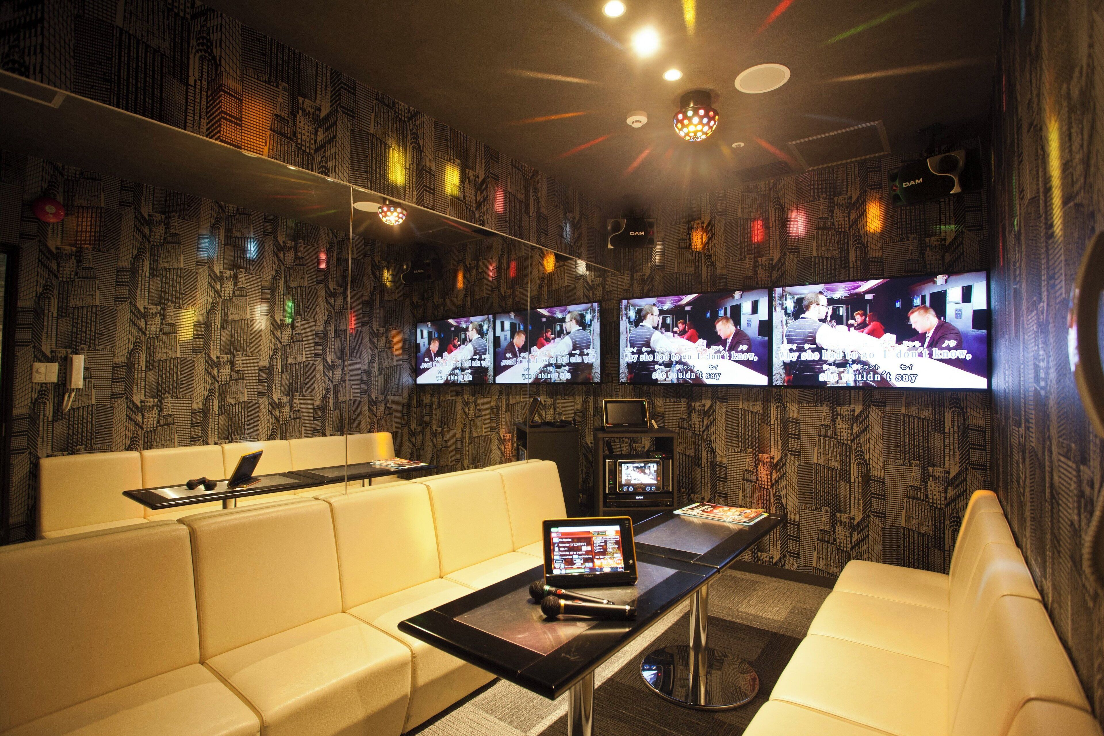 A modern lounge with multiple screens, a laptop, and a tablet on a table.