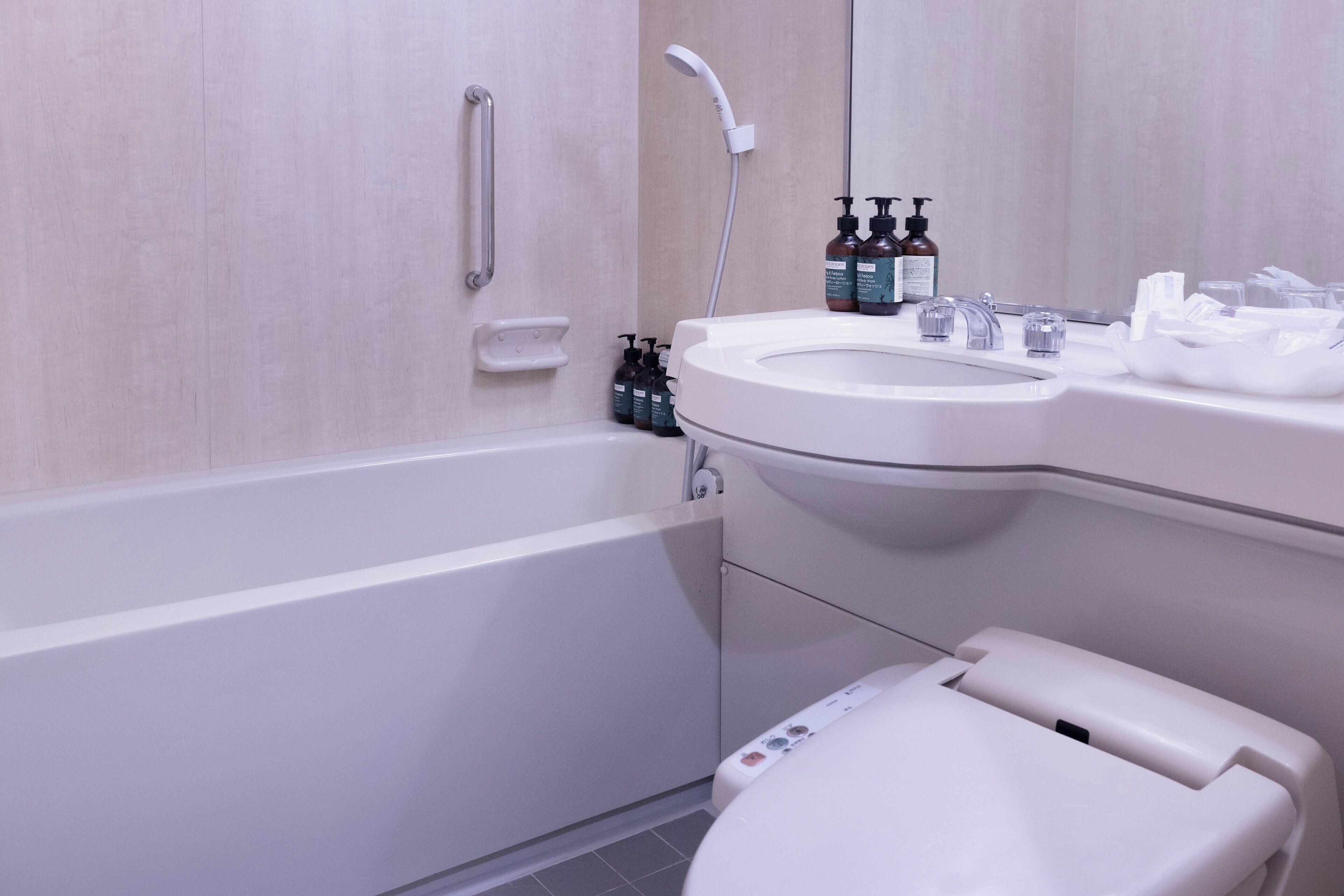 Un baño moderno con una bañera blanca, un lavabo con espejo y un inodoro.