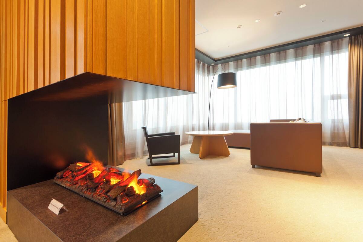Una sala de estar moderna con chimenea, una mesa redonda y un sofá.
