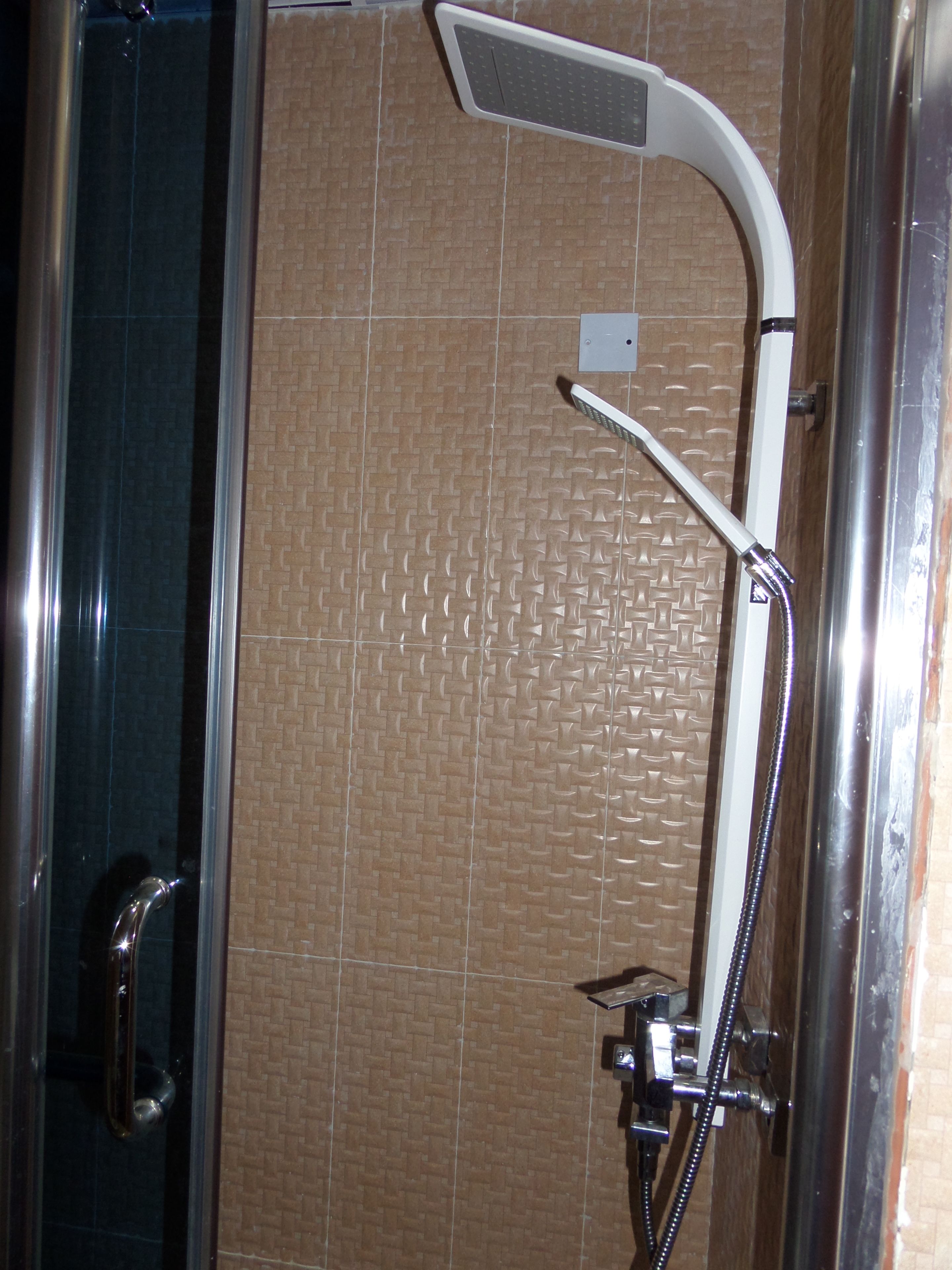 Chuveiro com chuveiro manual e painel de controle fixado na parede.