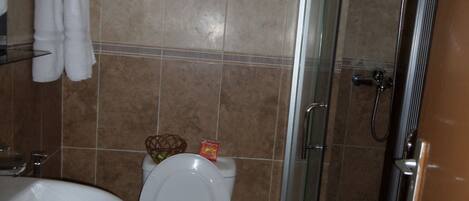 A bathroom with a toilet, sink, and shower.