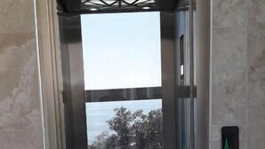 Een lift met een helder uitzicht op het exterieur door de glazen deuren.