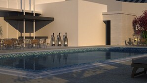 Un área de piscina moderna con sillones reclinables y mesas, una piscina cristalina y una zona de estar cubierta.