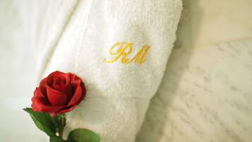 A white towel with embroidered initials "RM" and a red rose.