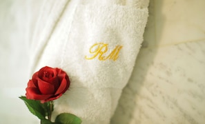 A white towel with embroidered initials "RM" and a red rose.