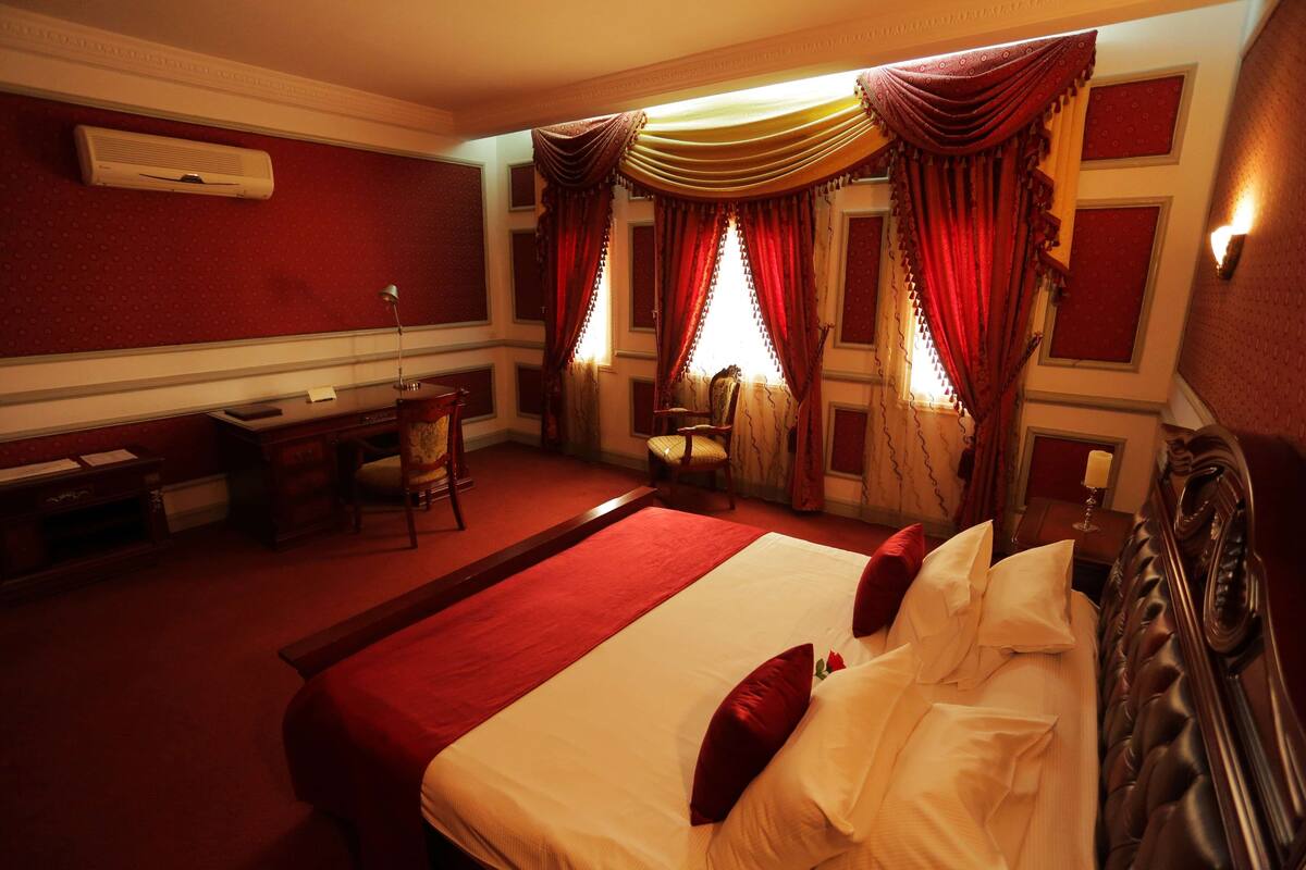 Ein Hotelzimmer mit einem großen Bett, einem Schreibtisch und einem Stuhl.