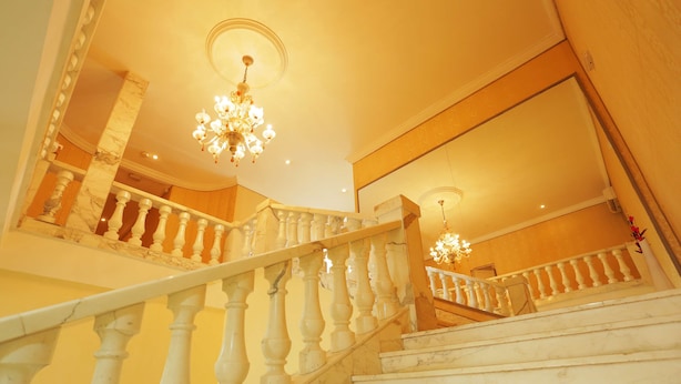 Un magnifique escalier en marbre, avec des marches et des balustrades blanches, menant à un balcon offrant une vue imprenable.