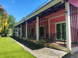 A two-story building with a covered porch, large windows, and a well-maintained lawn. - Phangpring Beach Resort (Tha Sala)
