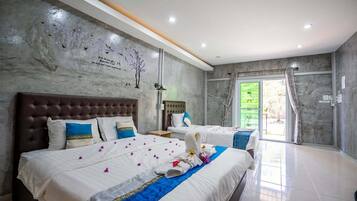Habitación de hotel con dos camas, una pared de mármol y vistas al exterior.