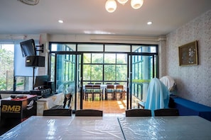 A conference room with a large table, chairs, and a view through glass doors to an outdoor area. - Phangpring Beach Resort (Tha Sala)