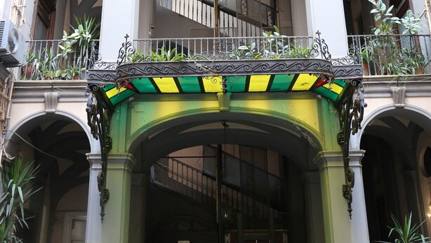 A multi-story building with a central courtyard, balconies with plants, and a staircase. - Dimora Delle Arti (Naples)