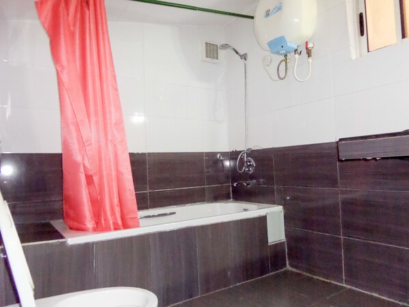 A bathroom with a bathtub, a shower, and a toilet. - Le Real Hotel (Lekki)