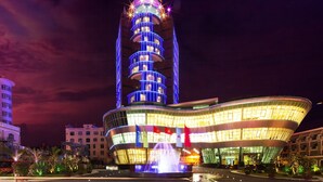 Un hotel de varios pisos con una torre distintiva y una fachada curva.