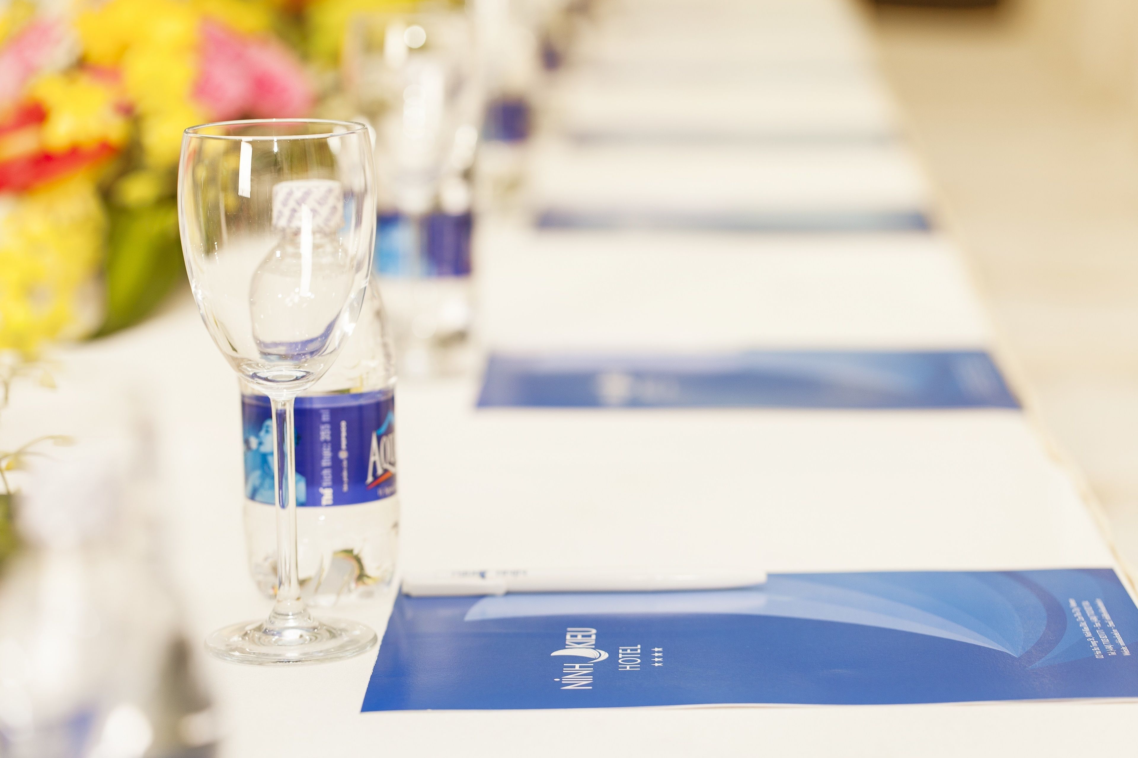 A hotel brochure on a table with a glass of water.