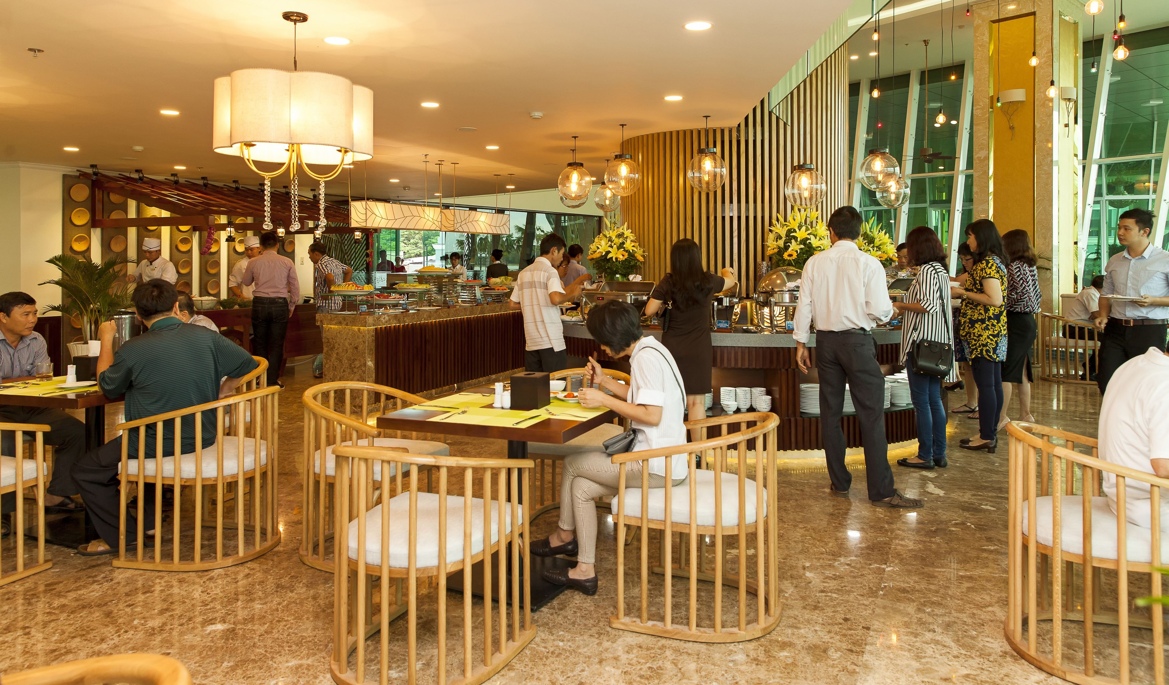 A restaurant with wooden chairs, a buffet, and a bar area.