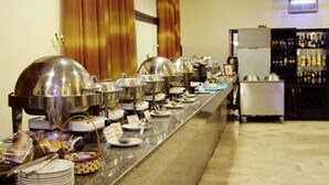 A buffet setup with multiple serving stations, a refrigerator, and a beverage bar. - Rockview Hotel Festac (Lagos)