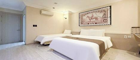 Habitación de hotel con dos camas, una obra de arte grande colgada en la pared y suelo de madera.
