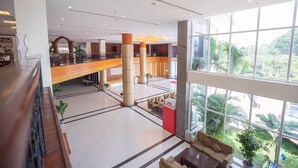 A spacious lobby with a high ceiling, a central atrium, and a view of the outdoors through large windows. - Vientiane Plaza Hotel (Vientiane)