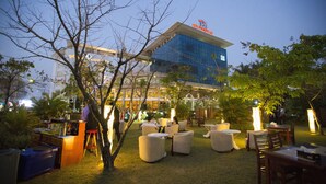 An outdoor seating area with tables and chairs, a bar, and a building in the background. - Vientiane Plaza Hotel (Vientiane)