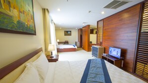 A hotel room with a large bed, a television, a desk, and a painting on the wall. - Vientiane Plaza Hotel (Vientiane)