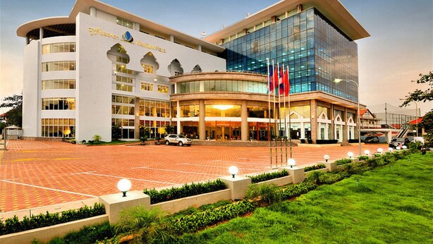 A modern hotel with a curved facade, large glass windows, and a central entrance with flags. - Vientiane Plaza Hotel (Vientiane)