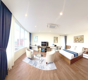 Una habitación de hotel con cama, escritorio, silla y un ventanal grande.