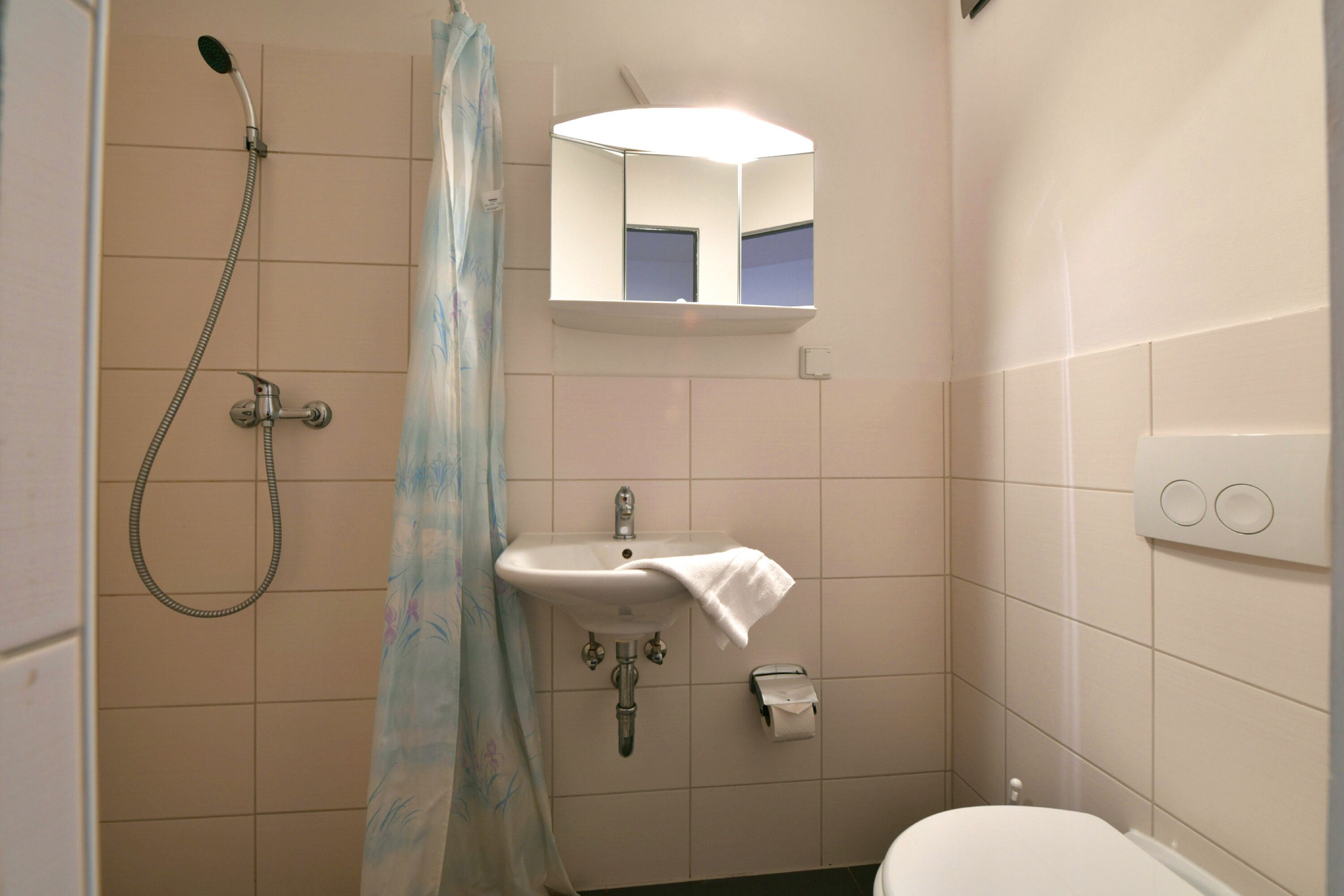 Un baño con ducha, lavamanos e inodoro.