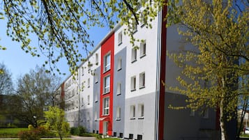 Stylish building with a unique design, surrounded by lush greenery and well-manicured gardens.