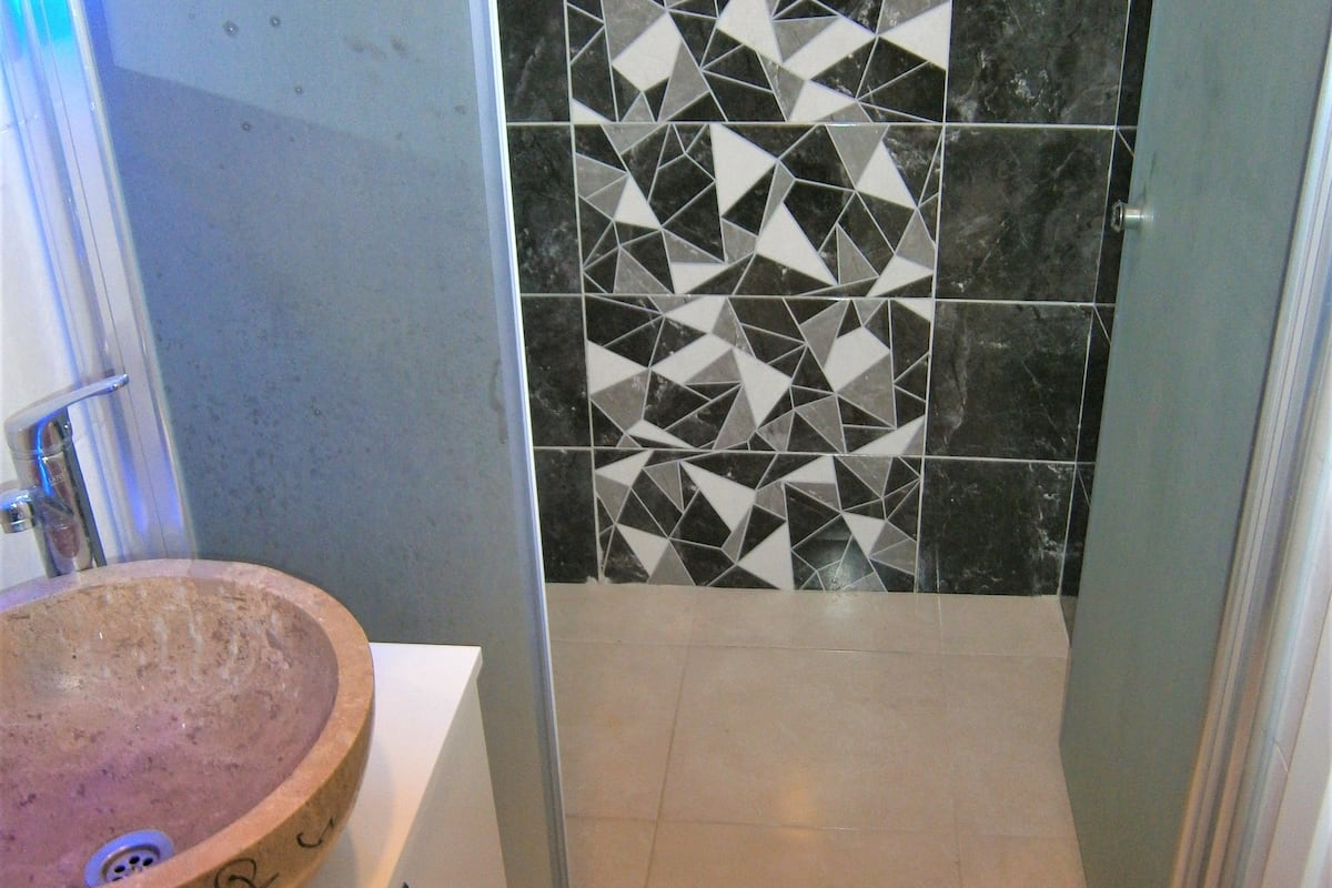 deluxe apartment | bathroom | shower, free toiletries, hair dryer, slippers