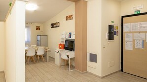 Un couloir donnant sur un coin repas, une petite cuisine et un petit espace bureau.