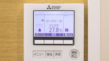 A Mitsubishi Electric thermostat with a digital display, buttons, and a control panel.