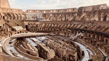 Un anfiteatro antiguo con varios niveles de gradas y una zona central para el escenario.