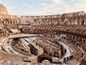 An ancient amphitheater with multiple levels of seating and a central stage area. - Torripa Collection - Domus Vittoria - Prati (Rome)