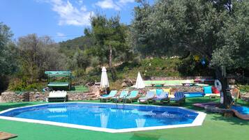 Una piscina al aire libre de temporada, sombrillas
