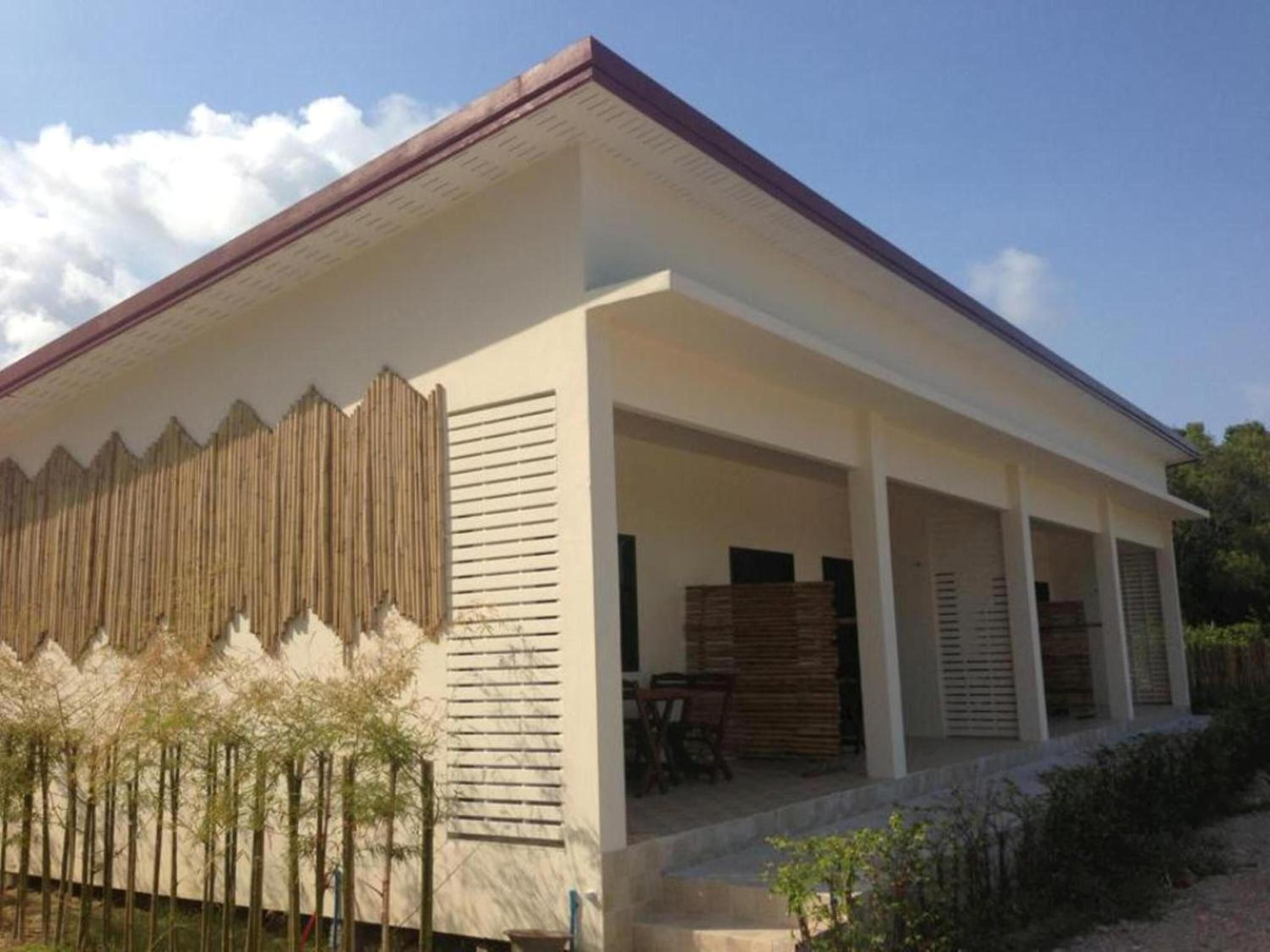 A modern house with a covered porch and a wooden fence.