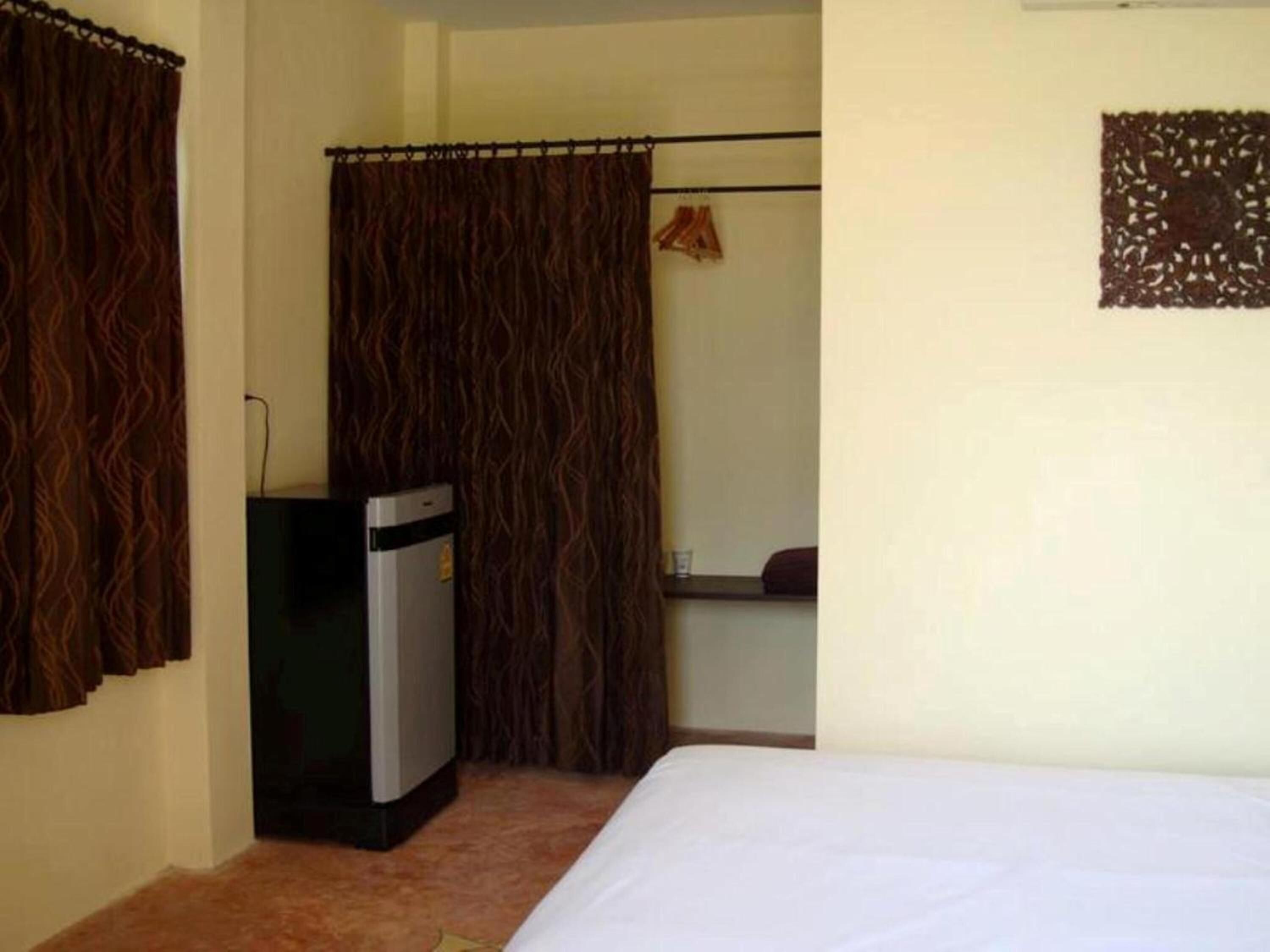 A small room with a bed, a desk, and a wardrobe.