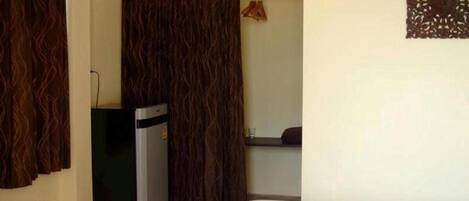A small room with a bed, a desk, and a wardrobe.