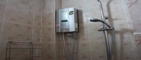 A bathroom with a shower, a wall-mounted heater, and a towel rack.