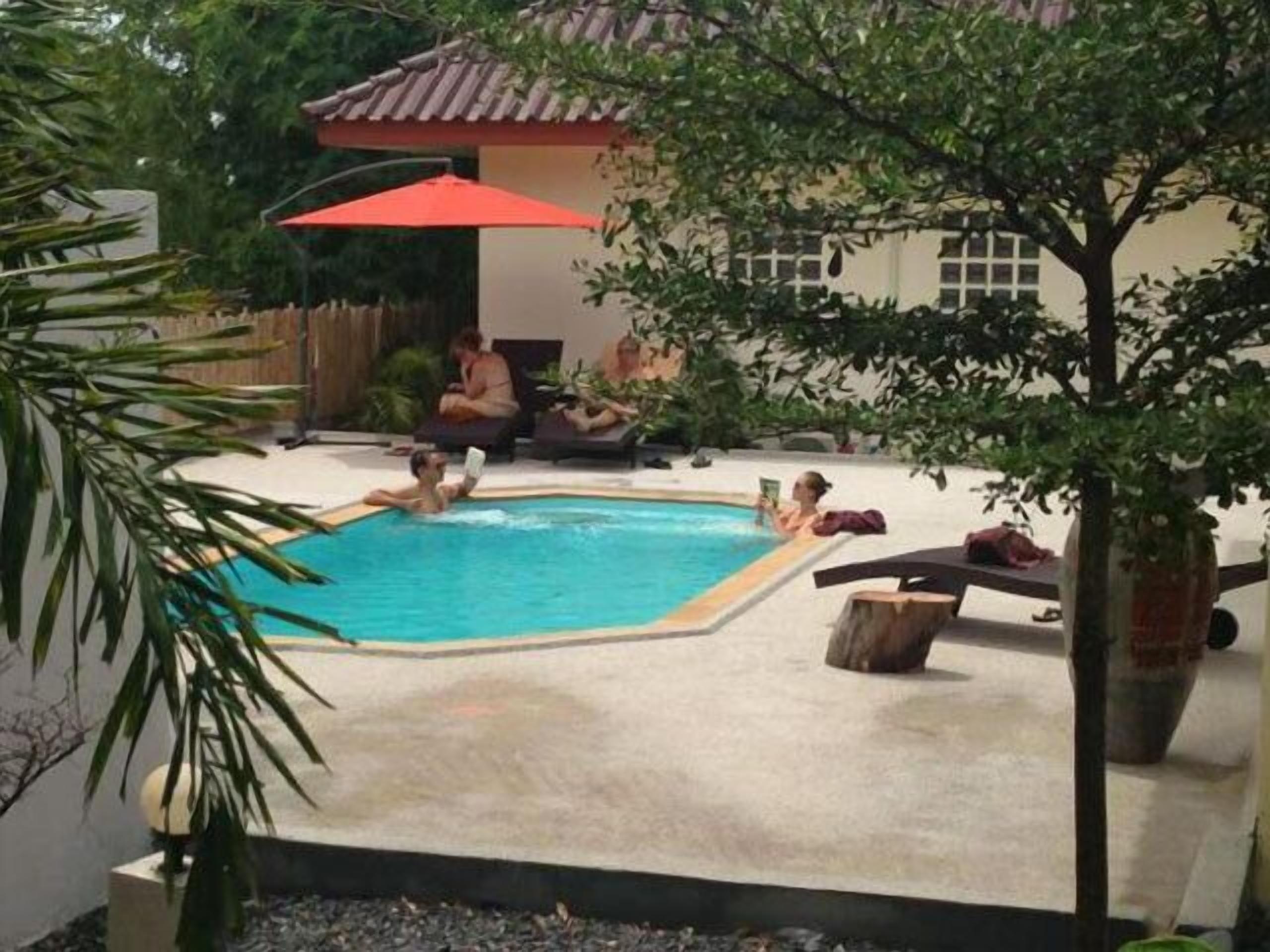 Una piscina al aire libre, tumbonas