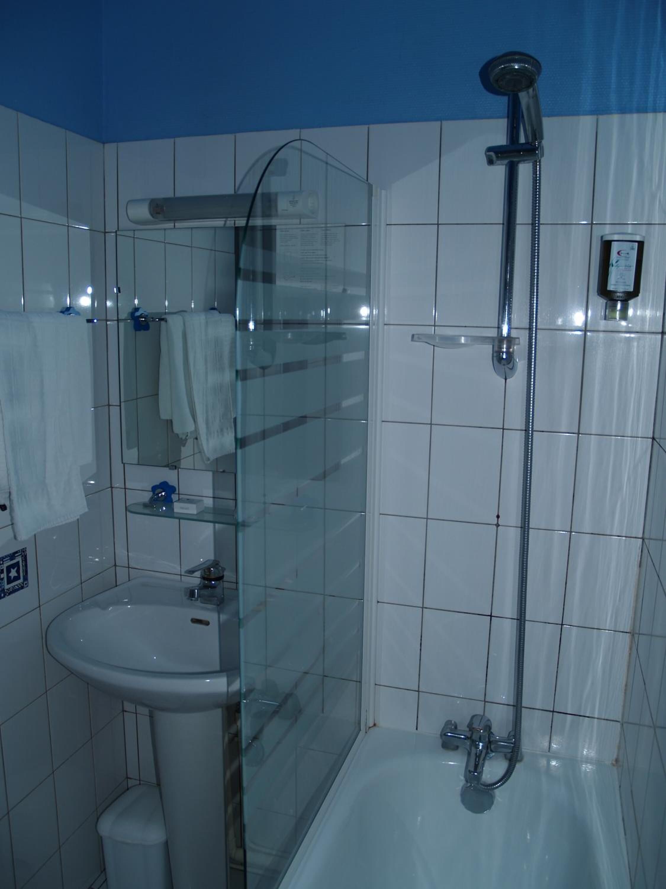 Ein Badezimmer mit Duschkabine, Waschbecken und Badewanne.